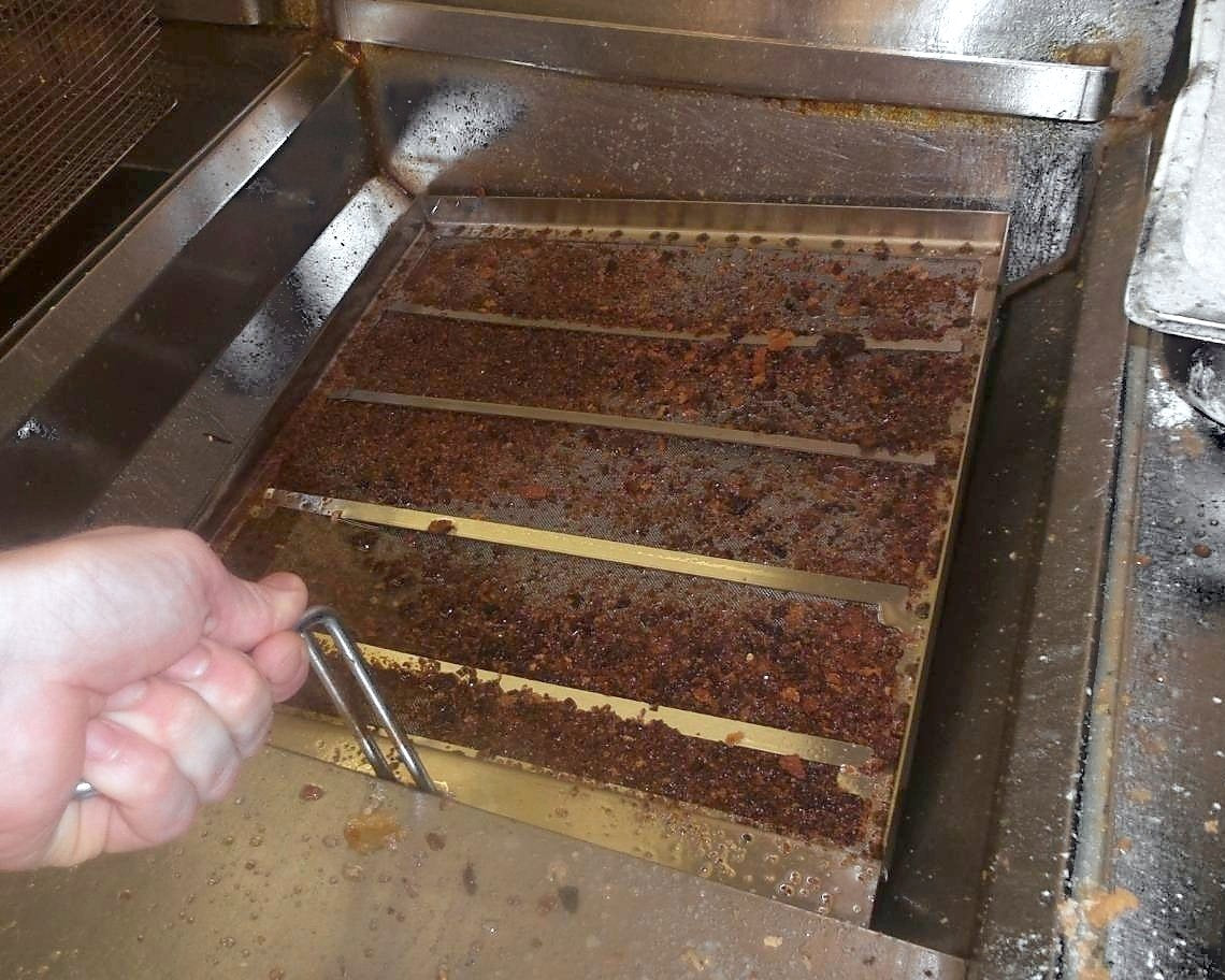 Lifting a Frymate filter tray full of crumbs out of the oil